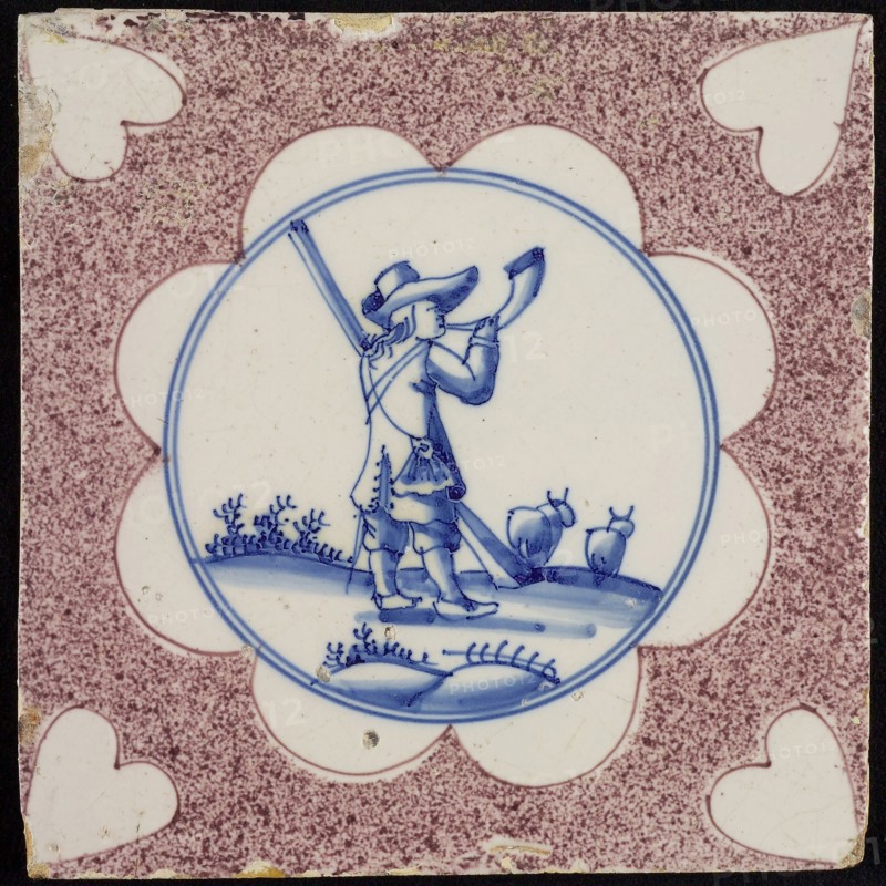 Figure tile, purple sprinkled tile, in scalloped blue circle hunter with horn and rifle, corner motif heart, wall tile