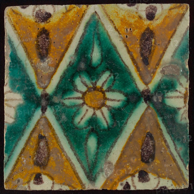 Floor tile, brown draft, green and yellow on white ground, central green oblique glass in which white flower with yellow heart