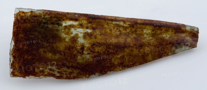 Green fragment of window glass with brown iridescence, window glass building material soil find glass, poured drawn Corner