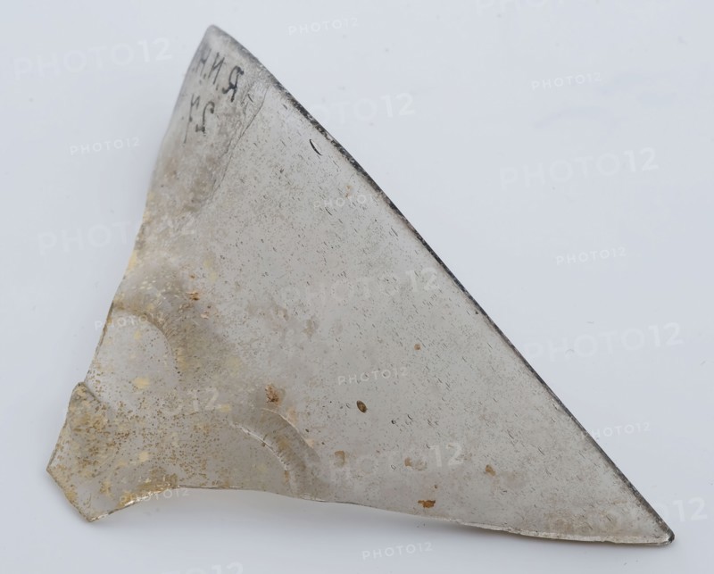 Two fragments of clear beaker, bottom and part of rim, beaker drinking glass drinking utensils tableware holder soil find glass