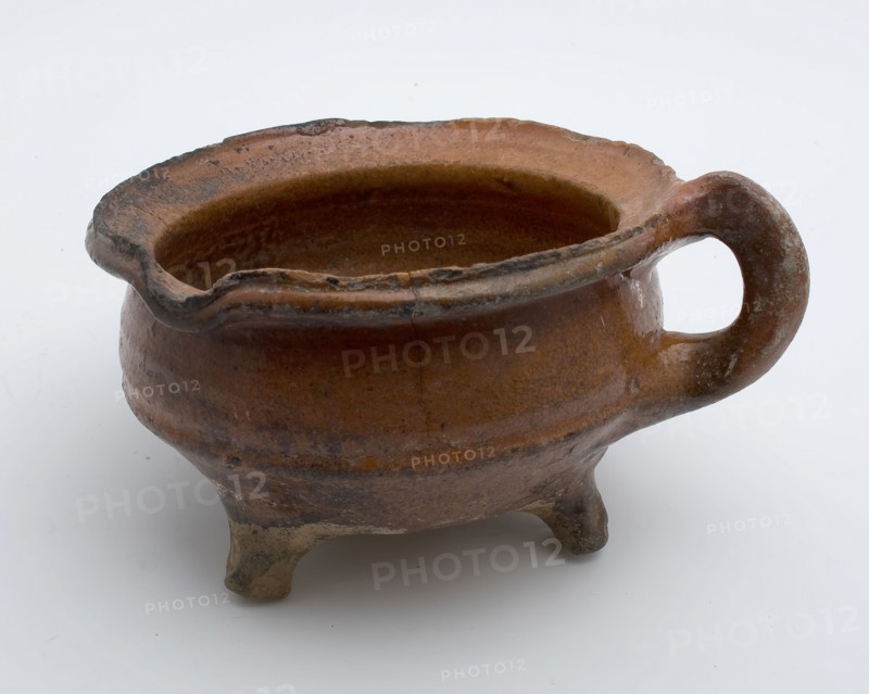 Pottery cooking jug, grape-model, red shard with lead glaze, vertical band-ear, on three legs, cooking jug