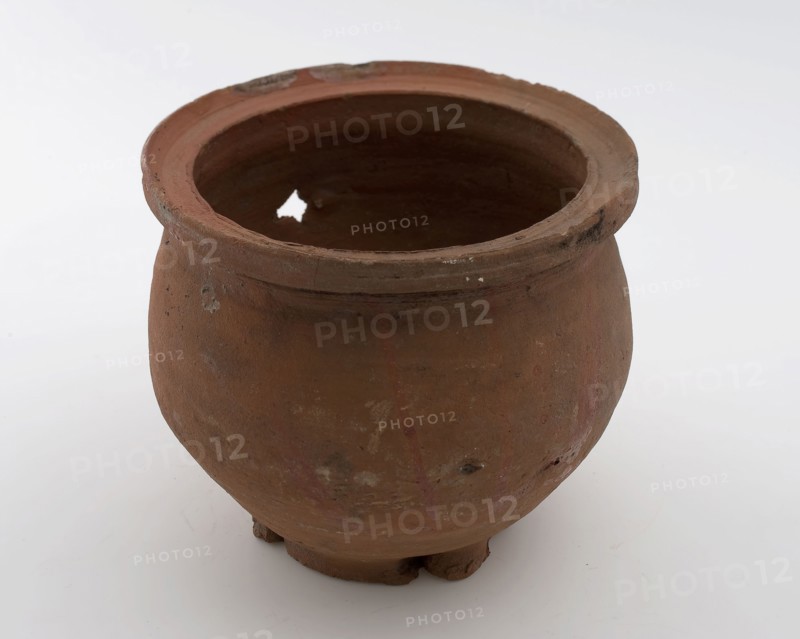 Earthenware flowerpot or colander, red shard, unglazed, five square holes in soil, on stand surface, flower pot holder earth