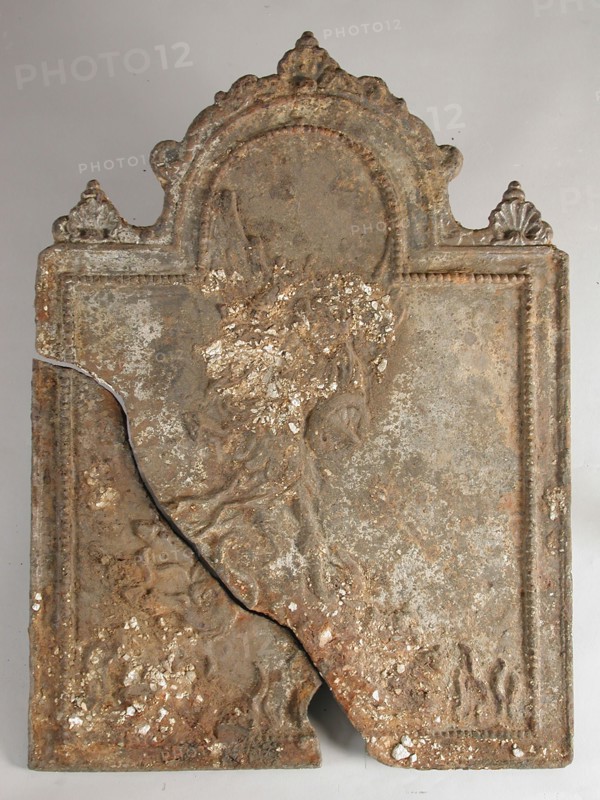 fireback soil foundry cast iron, cast Rectangular with arch at the top. On top of shell flanked by two dolphins and two shells