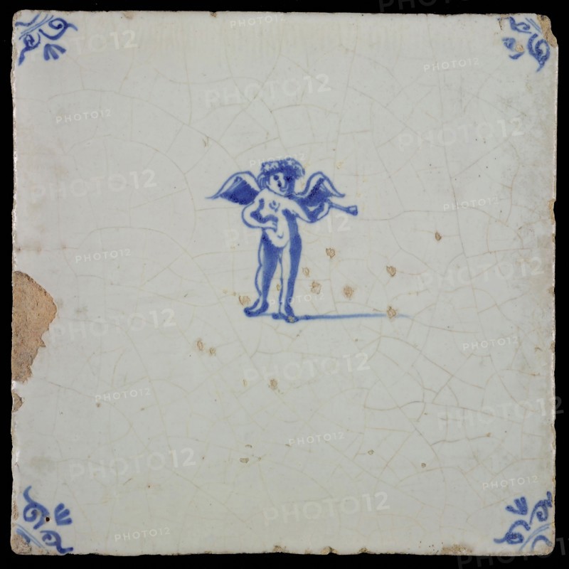 White tile with blue putto with wind instrument, ox-head in the corners, wall tile tile sculpture ceramics pottery glaze, baked