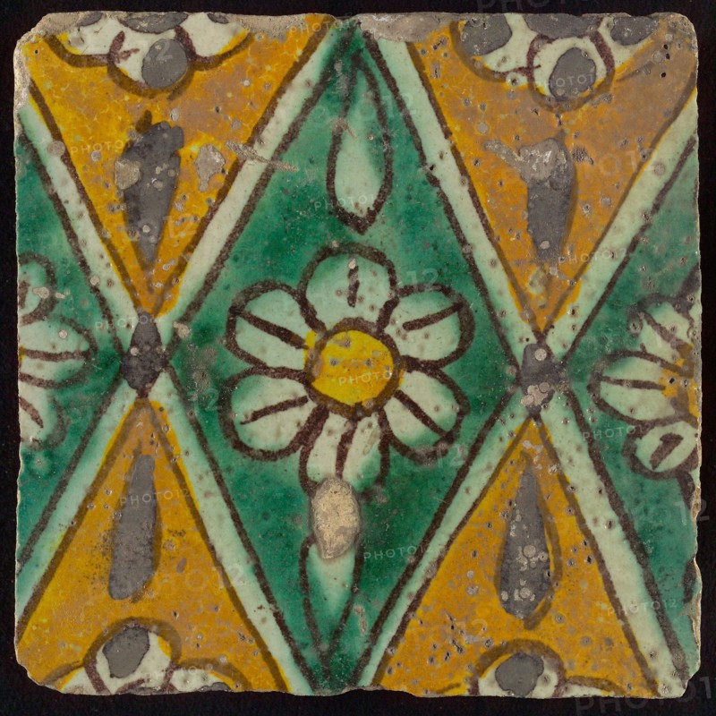 Floor tile, brown draft, green and yellow on white ground, central green oblique glass in which white flower with yellow heart