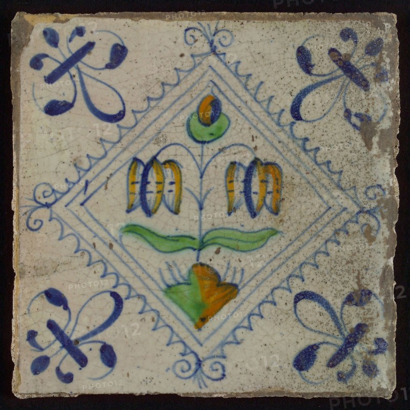 Tile, double flower on small ground in orange, green and blue on white, inside serrated square with plume, corner pattern french
