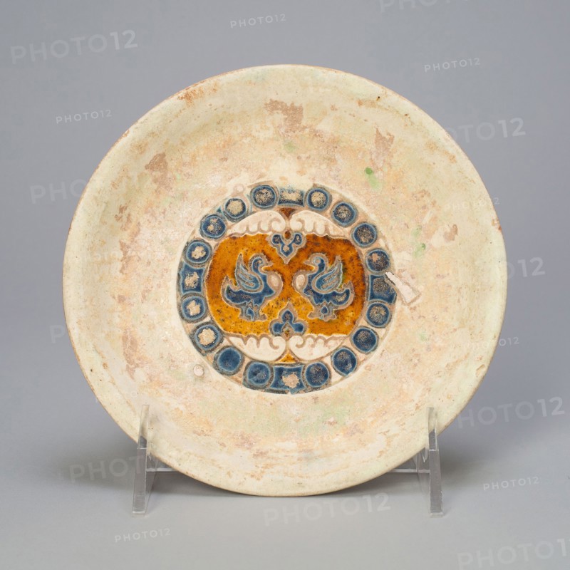 Dish with Two Birds Encircled by Beaded Roundels, Tang dynasty (618–907), China, Slip-coated earthenware with cobalt blue and lead amber glazes and underglaze mold-impressed decoration, H. 2.6 cm (1 in.), diam. 14.8 cm (5 13/16 in.)