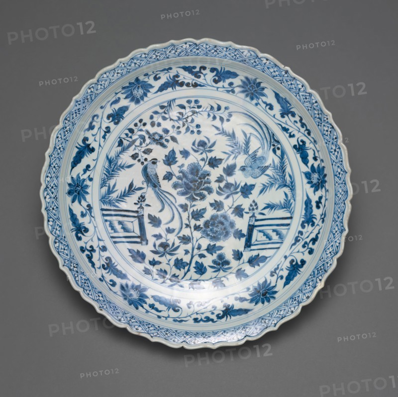 Shallow Dish with Long-Tailed Birds in a Garden of Stylized Peonies and Fronds, Encircled by a Scrolling Wreath of Camellia and Lotus Blossoms, Yuan dynasty (1279–1368), early/mid–14th century, China, Porcelain painted in underglaze blue, H. 7.9 cm (3 1/8 in.), diam. 45.4 cm (17 7/8 in.)