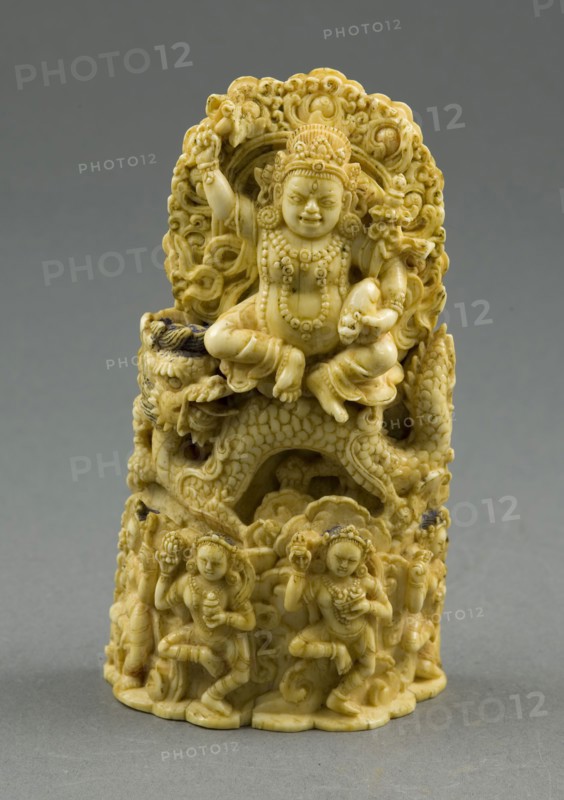 Jambhala, the God of Wealth, Seated on a Dragon, 15th century, Eastern Tibet, Tibet, Ivory with traces of gilding and pigment, 13.7 x 7.5 x 3.8 cm (5 3/8 x 3 x 1 1/2 in.), H. with pins: 15.3 cm (6 in.)