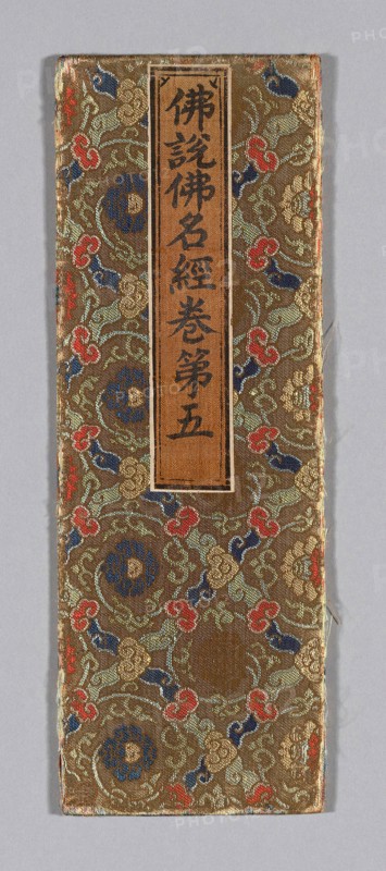 Sutra Cover, Ming dynasty (1368–1644), c. 1590s, China, Silk and gold-leaf-over-lacquered-paper strips, twill weave with twill interlacings of secondary binding warps and patterning wefts, wrapped over cardboard, applied label of silk, plain weave, with inscribed title painted and/or printed with ink, 34.1 × 12.2 cm (13 1/2 × 4 3/4 in.)