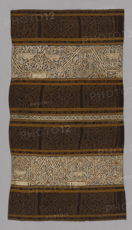 Woman’s Ceremonial Skirt (tapis), 19th century, Paminggir, Indonesia, Sumatra, Lampung, Sumatra, Six panels joined: four panels of stripes of cotton, warp resist dyed (warp ikat), plain weave with paired warps and stripes of cotton and silk warp-faced, weft ribbed plain weave with supplementary brocading wefts and a stripe of cotton, plain weave, embroidered with silk in double running, stem and surface satin stitches and two panels of cotton, plain weave, embroidered with silk in chain, double running, split, and surface satin stitches, mirror pieces, gilt-metal pieces attached with silk, 67 x 117.6 cm (26 3/ 8 x 46 1/4 in.)