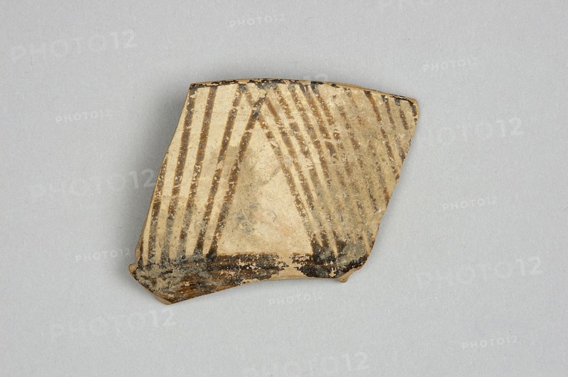 Fragment of a bowl, unknown Northern Mesopotamian workshop, painted pottery, geometric motifs, bowls, Near Eastern pottery, Eastern Gaulish Scene. Fragment of a bowl wall with a preserved thin rim edge and a transition to a flat, bottom. Before firing, the decoration consisting of geometric motifs was painted with ferrous clay on both sides of the bowl, over a layer of dry, very smoothed glaze. After firing, the painted decoration ranged in color from red to dark brown, while the background is shiny and cream-colored. The geometric motifs on the interior consist of groups of horizontal continuous and dotted lines, alternating with double lines, on which are placed small, elongated ovals. On the outer side, the decoration is a striped composition consisting of groups of several parallel diagonal lines inclined alternately to the left and to the right, and alternating triangular fields where the diagonal lines meet. Ca. 6500–ca. 5500 BC; Halaf culture, Northern Mesopotamia Iraq, Syria, T...