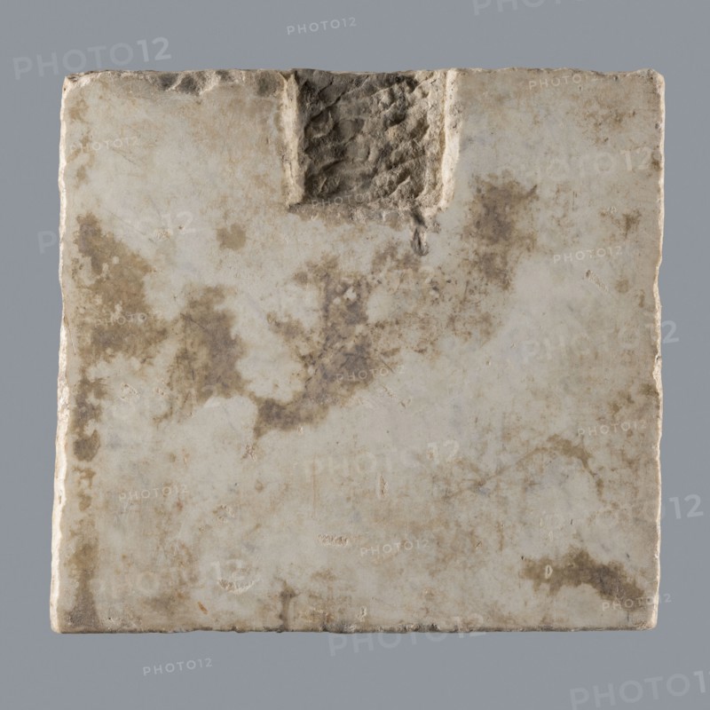 Latin grave inscription, unknown author, 2nd century, Roman Empire 27 BC–476, slab, epitaph, grave inscription, height 31 cm, width 28 cm, A square stone slab with uneven edges and a rough carved notch near the top center, showing a weathered surface with a mix of off-white, beige, tan, and brown mottled stains, small pits and scratches, and subtle variations in texture from smoother areas to rougher, eroded patches against a plain gray background.
