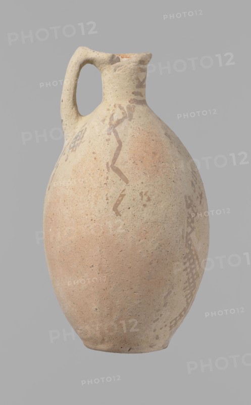 Jug, excavations at Nea Paphos Cyprus - equivalent, Cyprus, Cypriot pottery, Bronze Age Cypriot White Painted I. Jug with a large, oval and flattened belly, an indistinct foot, sloping shoulders, a low and narrow neck with a thickened outer edge of the spout. A small, cylindrical vertical handle, attached to the shoulders of the vessel and to the spout, protrudes slightly above the upper edge of the spout. Orange-cream clay. Cream engobe. Painted geometric decoration in brown. On the neck are zigzag bands of three parallel horizontal lines between each band the highest of which is at the edge of the spout. Body decoration in vertical stripes bounded on both sides by lines - in the centers of the sides of the vessel a zigzag of a single line; between them, two zigzags with a grid pattern, 4 meshes wide. At the bottom of the vessel, a continuous horizontal line intersects the lines delimiting the fields. Condition: slight loss at the rim. The surface of the vessel is heavily worn in many...