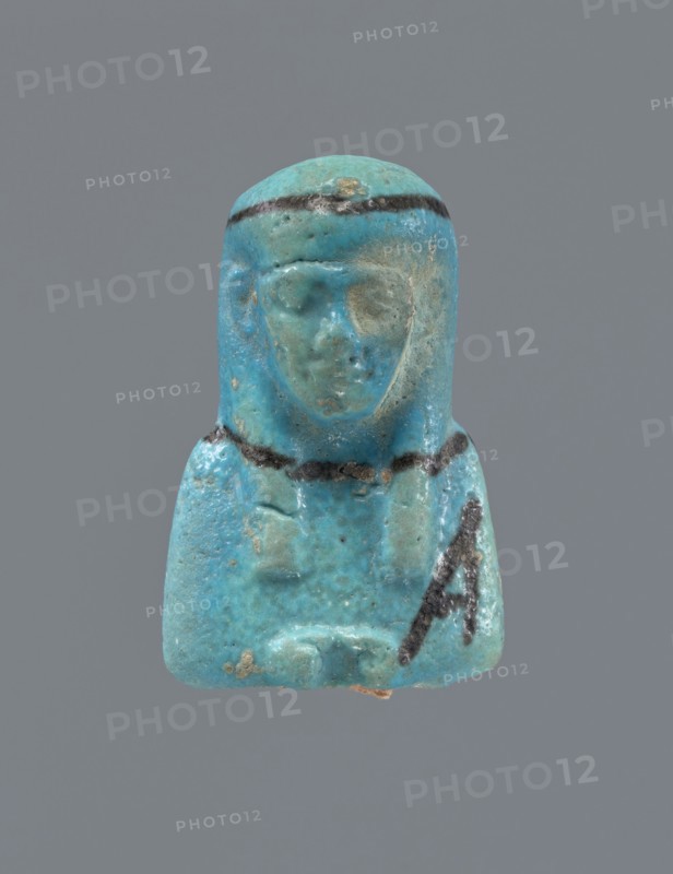 Ushabti, Mummy-shaped figurine, preserved head and fragment of torso. Arms crossed on the chest, hands placed at the same level, next to each other, holding hoes in each hand. On the back a rectangular basket is slung on strings over both shoulders. On the head is a long, smooth, three-part wig with a headband. Triangular face with proportional details; eyes slightly closed. Headband, tools, and facial details painted. ca. 945–ca. 715 BC; Third Intermediate Period, 22nd–23rd Dynasty, Egypt. Ushabti, height 5.2 cm., A small blue-green figurine of a seated person with a rounded headdress and a visible face, showing worn surface texture and areas of lighter and darker blue-green; the headdress and chest have thin dark bands, and there are a few small darker spots and patches of brownish discoloration on the surface, all set against a plain gray background.
