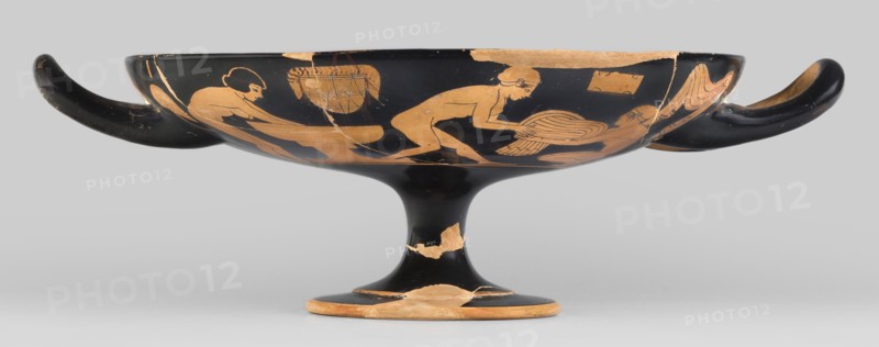 Red-figure kylix with a bathing scene, the Boots Painter ca. 460 BC. Bath iconography; Greek ceramics. Physical description: goblet with slightly parted rim edges, shallow bowl, low stem, and flat foot. Vices have a round cross-section, slightly raised tops reaching the line of the rim. Conical bottom. Sleeve-shaped foot. Scene: Women wash at lutrions bowls on high bases, pass around folded garments, and one of them ties the characteristic high boots. Technology: Thick, very good quality varnish, evenly distributed. Smooth surface. Traces of turning invisible, brush marks visible. Mixture: mica. Condition notes: Artifact glued from many fragments; visible conservation restorations; surface contaminated; visible secondary losses and chips; standing surface heavily worn. Provenance/attribution notes: Attributed to the Boots Painter. ca. 460 BC. Attica/Athens/Tarquinia Beazley 1928. Kylix, vessel. Dimensions: height 9.2 cm; width 29.8 cm; depth 22.8 cm; weight 0.53 kg., A shallow, footed ...