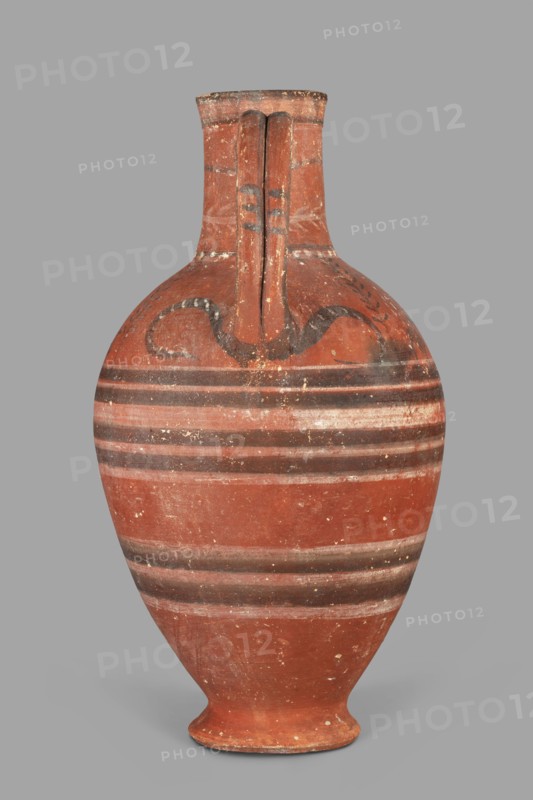 Jug with a figurine of a woman with a jug. Cypriot pottery, female figurine applique. Jug on a foot resembling an inverted echinus with a belly widening by convex shoulders, separated from a cylindrical neck with a straight spout. A two-part vise connects the neck with the shoulders; on the side opposite the vise is the bust of a woman holding a jug. Decoration in white and black paint: the belly at its widest point and along one-third of its height is decorated with alternating white and black concentric bands. Beneath the vise, a wavy black stripe extends onto the shoulders on both sides. On both shoulders are two birds among plants, a row of dots and a concentric stripe at the base of the neck; a branch with leaves encircles the neck above, and black triangles on a white background decorate the edge. Date: 480–400 BC Cypriot — Classical Period I. Origin: Arsinoe Marion. Vessel. Height 35 cm, width 19 cm, weight 1.72 kg., A single ceramic vessel with a rounded body that tapers to a n...