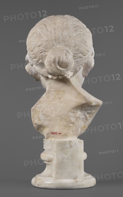 Portrait of a princess from the Julio-Claudian dynasty Julia?, unknown Roman workshop. Children's portrait, Roman sculpture, aristocracy Roman. The bust depicts a girl with a round, rather chubby face, turned slightly to the right; a rounded, elongated chin, and small, slightly pursed lips with a pronounced, wavy line of the upper lip. The almond-shaped, smooth eyes are rather shallowly set, with marked upper eyelids and barely visible eyebrows. The ears are carefully styled. The wavy hair is combed up and tied with a headband. At the back of the head, it is tied in a bun and a braid that falls down the middle of the head onto the smooth forehead. End of the 1st century BC–beginning of the 1st century AD, Roman Empire 27 BC–476. Sculpture; height 25.7 cm, width 16 cm, depth 12.5 cm, weight 11.5 kg., The image shows the rear view of a pale marble bust on a pale marble round pedestal against a solid gray background; the bust depicts the back of a head with hair gathered into a bun and sc...