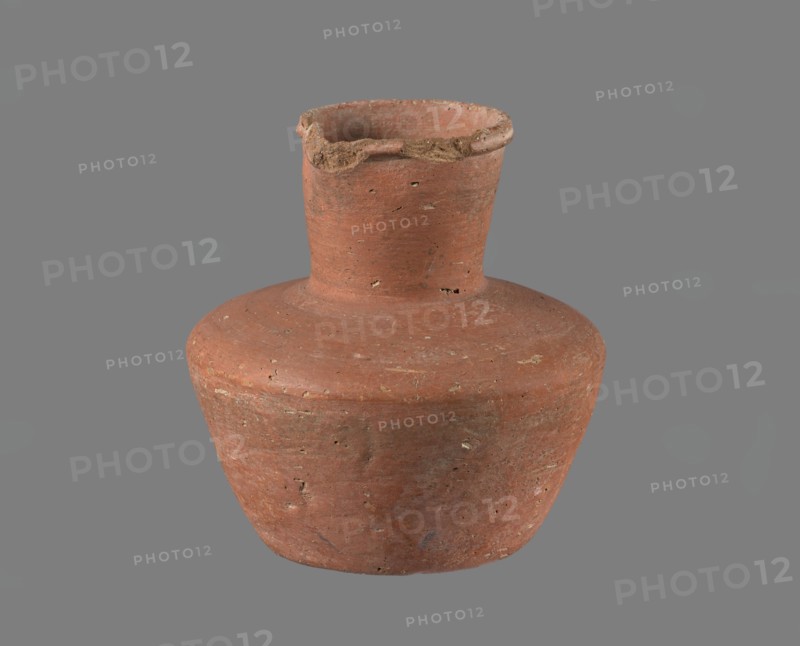 Jug, A small handleless jug with a biconical body, widest at about half its height. Broad, rather flat shoulders; a wide, almost cylindrical neck that widens slightly toward a profiled, irregular spout which slopes down on one side and extends to form a small pouring lip. Spout cross-section triangular with an approx. 1 mm central indentation on the outer profile. Neck was shaped separately and attached to the shoulders. Bottom almost flat, very slightly rounded. Made of Nile clay NB1/2, per the Vienna System. Outer surface and inner rim/neck leveled and covered with an engobe and polished/smoothed; remaining inner surface leveled. Red-brown in color. Nearly complete with a small fragment of the rim missing; outer surface slightly worn in places. Old Kingdom, cited as 4th–6th Dynasty c. 2686–c. 2181 BC. From Edfu. Vessel; height 11.4 cm; rim diameter 5.5 cm; shoulder diameter 10.8 cm; bottom diameter 7.1 cm. References: G. Brunton; T. Rzeuska., A single worn clay vessel with a rounded ...