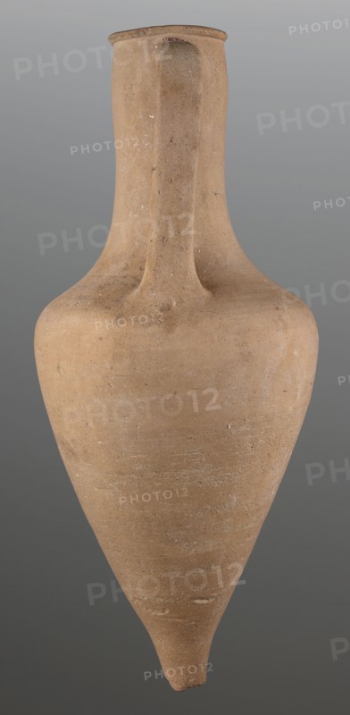 Stamped transport amphora with a Greek inscription Argeio — transport amphora with a pointed bottom and a conical belly, rounded at the sloping shoulders, merging into a cylindrical long neck slightly bulging under the annular rim. The neck is stamped; letters arranged in two rows reading Argeio. Ribbon-like handles protrude from the shoulders and run straight up, bending in an arc where they join the neck under the spout. A rectangular stamp with deeply recessed letters in two rows is impressed on the upper part of the neck; the stamp likely refers to the maker or an official. Eponymous-manufacturer's stamps; trade/transport vessel; Greek pottery, ancient pottery, stamps. Dated 400–390 BC. Origin: Heraclea Pontica Bithynia; found in Olbia. Vessel type: transport amphora. Weight 6.326 kg; height 63 cm; diameter 26.5 cm., A tall, narrow vessel with a tapered pointed base and a rounded shoulder, made of a coarse, sandy material in shades of light brown and tan, with subtle darker brown s...