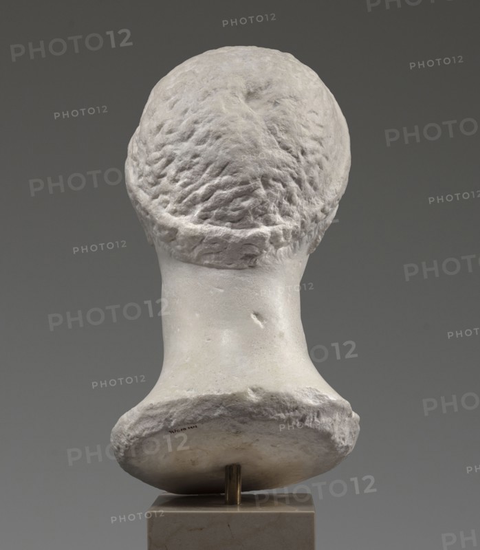 Head of a woman Berenice II or Arsinoe II, unknown author, restitution Przeworsk, Greek sculpture, female portrait, 330–30 BC; Hellenistic period, Alexandria, sculpture, The image shows the back of a sculpted head and neck displayed on a small rectangular pedestal; the sculpture surface is predominantly off-white and pale gray with textured, rough areas on the hair and a smoother finish on the neck, and the background is a uniform medium gray.