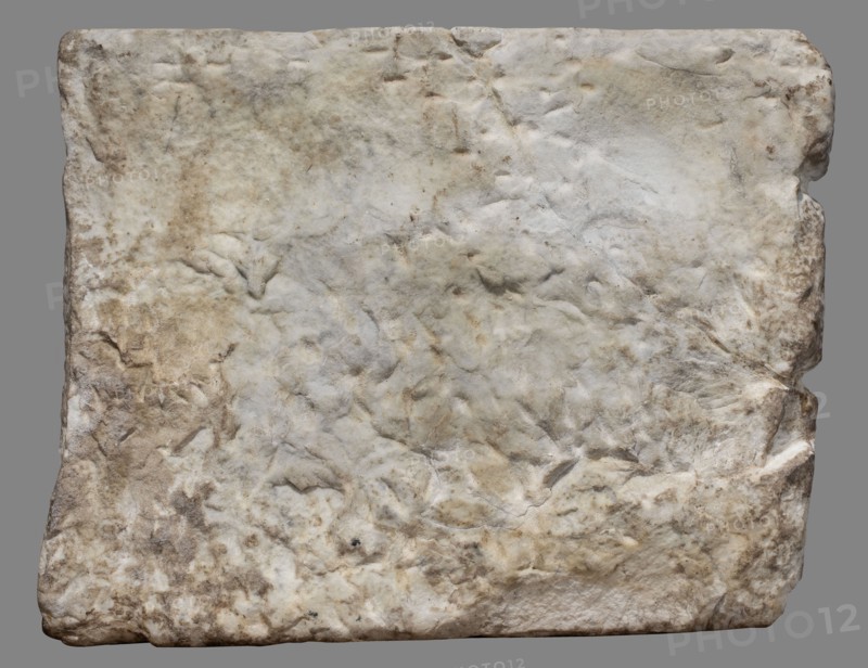 Funerary stele with a depiction of the deceased Hermiones and a Latin inscription, unknown Roman workshop, female images, sepulchral funerary architecture, Latin inscriptions, dated 240–245, Roman Empire 27 BC–476, slab; height 47.5 cm, width 60.5 cm, depth 6 cm, weight 32 kg, A roughly rectangular slab with an uneven, weathered surface showing a mix of off-white, beige, light brown, and pale gray tones; the surface has many shallow depressions, bumps, and irregular textures with softer rounded edges and worn corners, and a few darker brown patches and subtle shadowed creases that emphasize the stone-like irregularities.