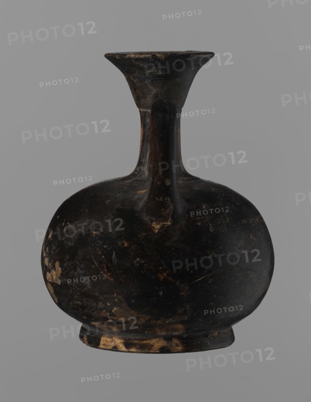 Aryballus lekythos, Reddish-brown clay with black, slightly shiny, well-covering varnish, also on the underside of the foot and inside the handles. Low echinus-shaped foot, spherical slightly flattened body; low narrow neck with a funnel-shaped rim with a thickened lip. Body decoration: bird in left profile with beak raised. Ceramics, red-figure pottery; Greek pottery, ancient vessel lekythos / aryballus. Southern Italy, 4th century BC 2nd half of the 4th century BC. Height 9.3 cm, width 7.6 cm., A dark rounded vessel with a narrow neck and flared rim, showing worn areas and patches where the surface is lighter; the vessel is primarily black with spots of brown and tan wear, set against a uniform gray background.