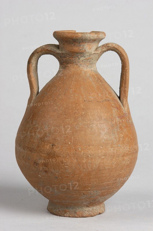 Pelike, decoration painted on the firnis: between the handles on both sides a wavy linear tendril with volute-like curled side shoots; above it a wavy line twist?. At the height of the base of the handles, two horizontal parallel lines. 332–30 BC Hellenistic period. Unknown place of origin. Vessel; height 12.5 cm, width 9.8 cm., An earthenware vessel with a rounded body and a narrow neck flaring to a short rim, showing a textured surface with some rough patches and chips, and two symmetrical looped handles extending from the neck to the shoulder; the object is predominantly terracotta orange with areas of lighter beige and grayish weathering, set against a pale neutral background.