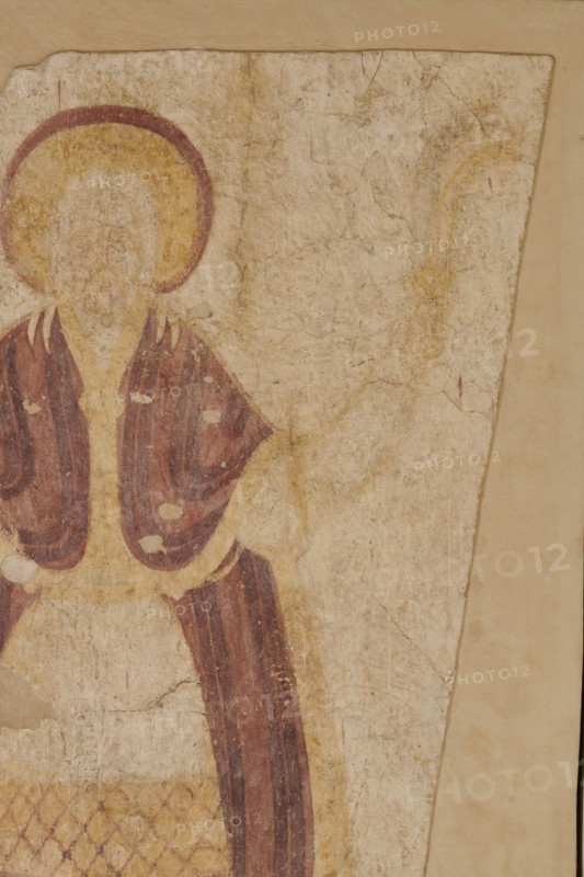 Wall painting: High Priest Aaron, Nubian workshop; wall painting; censer iconographic; liturgical vestments; Faras Sudan; Old Testament high priest iconographic; arms spread to the sides; in his right hand the priest holds a censer in the shape of a hemispherical cup on a foot suspended on three long chains; in his left hand a leafy branch and a box . A yellow nimbus outlined with a red line around the figure's head. The face is heavily blurred, features invisible. The ankle-length white tunic is decorated with a diagonal red check pattern at thigh level, followed by a light purple stripe with vertical dark purple stripes, a diagonal checkered belt, and then another vertical stripe pattern. The high priest's shoulders are covered by a light purple mantle with darker purple vertical stripes, fastened at the chest with an oval clasp. On his feet the figure wears dark purple slippers. Original plaster: 224 x 147 cm; wall painting; 1st quarter of the 10th century; height 253 cm, width 184 ...