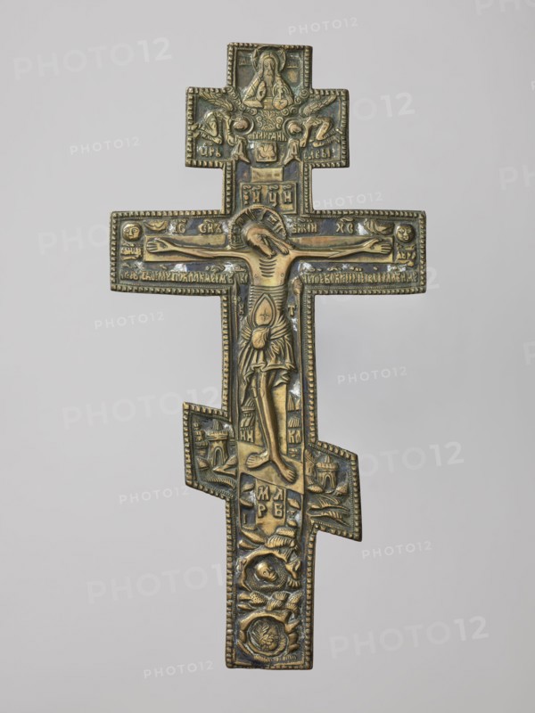 Cross: Crucifixion of Christ, Old Believers workshop; crosses; Lord of Hosts iconography; Jesus Christ Bible; God the Father iconography; sun iconography; Crucifixion iconography; moon iconography; Golgotha iconography; Adam Bible; instruments of the Passion of the Lord iconography; skull iconography; Jerusalem Israel/Palestine; Holy Spirit iconography; Old Believers; inscriptions; halo iconography. On the eight-pointed cross is an image of the Crucifixion. Below the cross on which Christ is suspended is a grotto with Adam's skull and the tree of Seth; at the level of the footstool is a view of Jerusalem; on two sides of Christ on a long beam are the sun and the moon. In the upper part, a bust-like image of the Lord of Hosts is depicted, below which is the dove of the Holy Spirit. The relief is deep in cast, and the style is rather schematic, somewhat archaizing especially visible in the facial features. The background features navy blue and white enamel. The reverse is engraved with t...