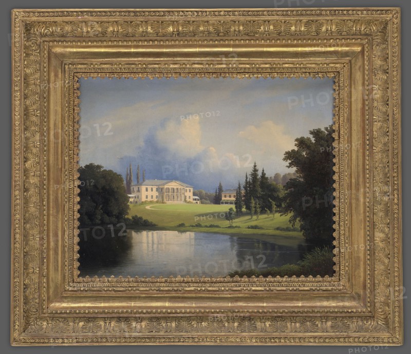 Palace in Szpanów, Peyer, Heinrich fl. 1844–1862 painter, Radziwill, palace Nieborów, after 1852, painting, height 32.5 cm, width 40.0 cm, A framed painting showing a landscape with a large classical white building on a green lawn beside a reflective body of water, surrounded by groups of trees and shrubs. The sky above is pale blue with soft white and gray clouds. Trees in the scene are various shades of green and dark green, with some brown trunks visible. The water reflects the sky and surrounding greenery in muted blues and greens. The painting is set in an ornate gold frame with textured decorative patterns and a warm metallic gold color.