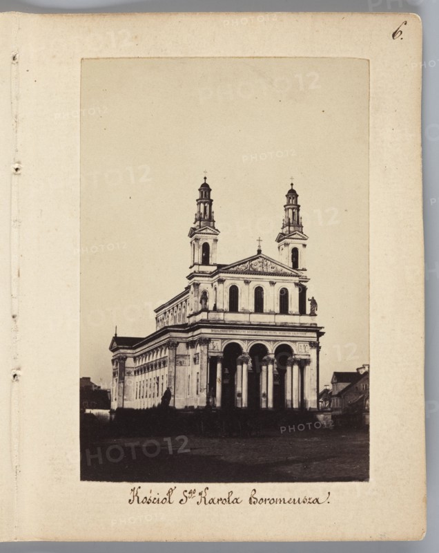 Church of St. Charles Borromeo designed by architect Henryk Marconi, view of a fragment of the southern frontage of Chlodna Street, photograph by Karol Beyer 1818–1877; inscription/attribution to Leopold Méyet 1850–1912. Subject: Church of St. Karola Boromeusza, Warsaw; date: 1861–1863. Photograph nature photography, photographic print: image height 9 cm, width 6.2 cm; support: height 11.3 cm, width 8.8 cm., The image shows a sepia-toned photograph of a large neoclassical building with a façade featuring several tall arches and columns, two symmetrical towers rising above the structure, and decorative pediments; the building sits against a pale background and is mounted on an off-white page with a few small blemishes and a rounded outer corner, and there are a few small dark shapes near the base of the building and a group of smaller buildings visible to one side, with overall colors including beige, brown, black, and off-white.