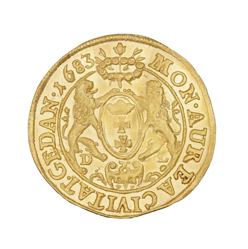 Gdansk ducat, John III Sobieski King of Poland; 1674–1696, Daniel Lesse mintmaster, 1656–1685, Poland, Gdansk, coin, A circular gold-colored coin with a raised rim, showing a central shield held by a pair of stylized lions in relief and topped by a small floral or wreath motif; the coin surface is textured with engraved decorative elements and an outer band containing raised characters around the edge; visible colors include shades of gold and yellow with subtle darker gold shadows and highlights.