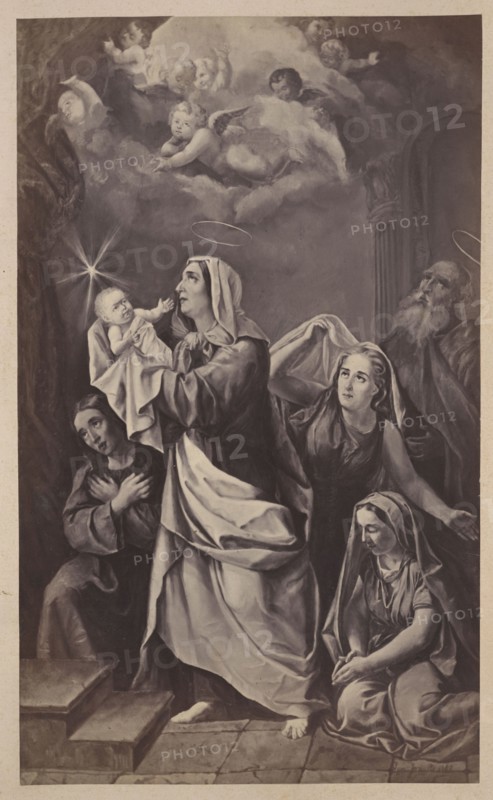Photograph of a painting: Ignacy Jasinski 1833–1878, The Offering of St. John the Baptist, 1862; Ignacy Jasinski, Polish painting, reproduction, religious painting, John the Baptist — iconography; photograph on cardboard pasted in as the 18th page of an album, ca. 1880; photograph of a work of art, photographic print: height 27.1 cm, width 16.2 cm; cardboard: height 40.2 cm, width 29.8 cm., A grayscale image shows a group of robed figures arranged in a vertical composition beneath a clouded sky with several cherubic figures and a bright star-like light. A central standing woman wearing a hooded garment and flowing drapery holds an infant wrapped in cloth while gazing upward; a faint halo shape hovers above her head. To her left, a seated figure with folded arms looks toward the infant. To her right, a woman with exposed arms looks upward and reaches behind the central figure toward a draped cloth, and a kneeling woman in a headscarf sits with hands clasped, looking downward. An older b...