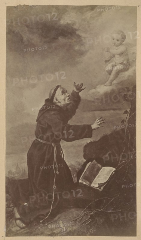 Photograph of a painting: Ignacy Jasinski 1833–1878, St. Francis; Ignacy Jasinski, reproduction, religious painting, Francis of Assisi St.; 1181 or 1182–1226 — iconography; print glued across the entire surface to the verso page of an album page, ca. 1880; photograph of a work of art; photograph in an album; height 22.1 cm, width 12.5 cm; painting, Polish, medium: painting., A sepia-toned scene shows a robed figure kneeling on a rocky ground, wearing a dark brown robe with a rope belt and sandals, reaching upward with both hands and looking toward a small childlike figure seated on a pale cloud; the child appears light-skinned and wears a light garment, with light-colored hair and a relaxed posture. The background includes a cloudy sky in shades of gray and brown and a distant landscape with indistinct shapes. Near the kneeling figure is an open book resting on the rock, its pages lighter in tone, and a few dark plants or branches extend from the right side of the image. The overall co...