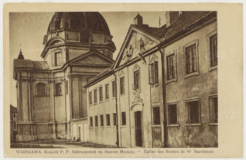 Warsaw. Church of the Blessed Sacrament Nuns in the Old Town. - Eglise des Soeurs de St. Sacrement, Bulhak, Jan 1876-1950 photographer, Church of the Blessed Sacrament Nuns Warsaw; New Town Market Square, Warsaw Masovian Voivodeship, ca. 1930, postcard, height 9 cm, width 13.8 cm, A sepia-toned photograph of an architectural street view showing a large domed building adjacent to a row of connected buildings with decorative facades and multiple windows. The dome and its supporting structure appear on the left, with classical architectural details and pilasters, while the row of lower buildings stretches to the right featuring a central entrance topped by sculpted ornamentation and a triangular pediment. Several windows are visible along the façades, some with open shutters, and the exterior surfaces show texture and weathering. The street in front is mostly empty, and the overall color palette includes shades of brown, tan, beige, and cream.