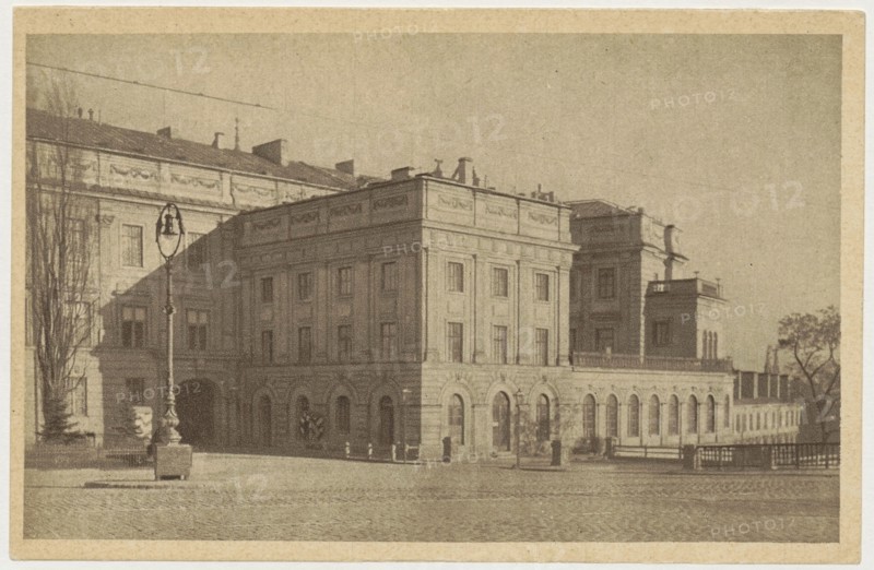 Warsaw. Royal Castle, photographer Jan Bulhak 1876–1950; co-author: St. Wojciech's Printing House and Bookstore Poznan; publisher: Polish Society of Railway Bookstores Ruch; subject: Royal Castle Warsaw, Castle Square, Warsaw Masovian Voivodeship; ca. 1930; postcard; 9 cm × 14 cm., The image shows a large classical building with multiple stories and arched ground-level openings, rendered in sepia tones of brown and beige; a paved open area in front leads to the facade, where a tall ornate street lamp stands on a stone base near a few bare trees; the building features rows of rectangular windows, decorative cornices, and flat rooflines with small rooftop structures, and a low railing or balustrade runs along part of the upper level; to the right, a smaller attached structure and a group of trees are visible, all depicted in muted brown and tan hues.