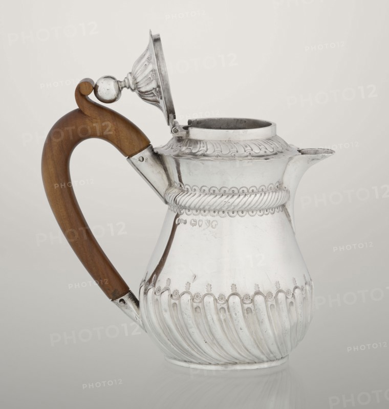 Coffee pot by John Septimus Beresford London; goldsmith; active 1880–1889. Pear-shaped jug, spirally clacked in the lower part, smooth above, decorated with a half-cylinder under the upper flared rim; short spout; wooden handle not original mounted in sleeves; hinged domed lid, spirally knotted, topped with a ball. 1888–1889. Great Britain, England, London. Vessel. Height 13 cm; width 12 cm; depth 6.8 cm; weight 179 g., A reflective silver pitcher with ornate raised ridges and decorative scalloped edges sits against a light background, featuring a curved wooden handle in warm brown attached to the body with silver fittings, a hinged domed lid that is open showing the interior rim, a short spout, and surface details including twisted rope-like bands and embossed floral motifs, with visible colors of silver, brown, and neutral off-white in the background.
