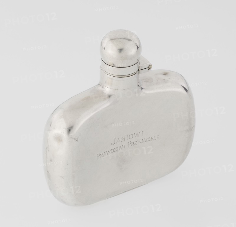 Hip flask by James Dixon & Sons Sheffield; goldsmiths, fl. 1806–, silver hip flask, smooth cuboid with rounded edges, narrow neck and spherical hinged stopper. Engraved inscription JAN / TRUE FRIENDS. 1925/1926. Sheffield, England. Vessel; height 9.9 cm, width 9.6 cm, depth 2.6 cm, weight 110 g., A smooth, reflective metal flask with a rounded rectangular body and a short neck topped by a domed cap with a small hinge; the metal surface shows a few subtle scratches and scuffs and reflects light, appearing predominantly silver with areas of slightly darker grey tones.