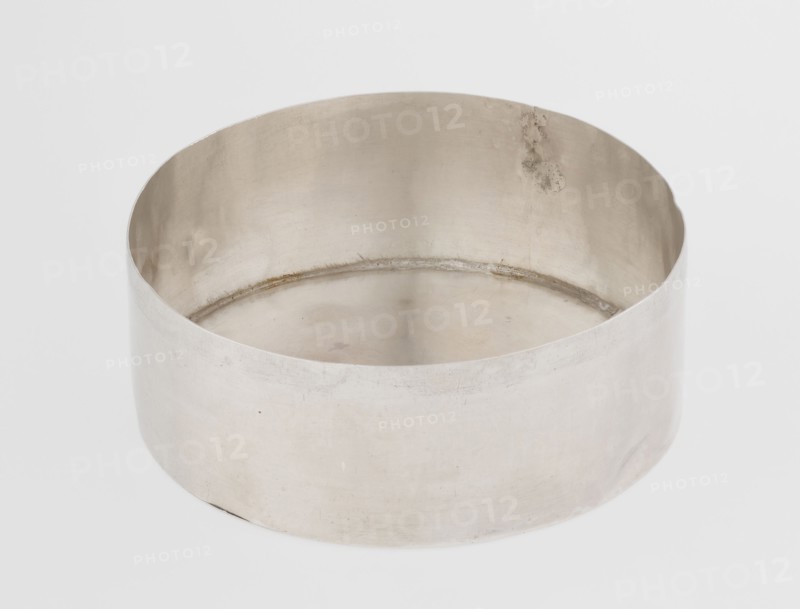 Toilet box; maker: Edward Fernell fl. 1779–1796?, goldsmith; material: scrap, function: toilet accessories/container; form: round box, smooth with slightly domed lid edged with a profiled band; style: Georgian, Classicism, George III; date: 1792/1793; origin: London, England, Great Britain; dimensions: height 4.2 cm, diameter 8.2 cm; weight 115 g., A round, shallow metal container with smooth curved sides and an open top sits on a plain light background; the metal surface shows a muted silvery-gray color with subtle variations in tone, faint scratches, and a few small darker spots, and the interior rim displays a slightly darker band and some areas of discoloration.