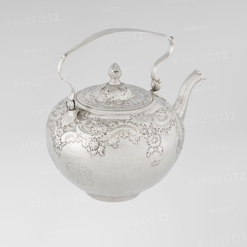 Buliera kettle for boiling water, maker: Benjamin Gignac fl. 1745–1774, goldsmith. Rococo rocaille style with repoussé rococo decoration and floral/plant ornament. Spherical buliera with a flat bow mounted on volutes; side spout; centrally arched cover topped with a pine cone. Decorated with two engraved coats of arms — one four-field in an oval beneath a baronial crown, the second in an illegible shield. Missing base with heater. Date: 1753/1754, London, England, Great Britain. Vessel. Height 22 cm, width 24 cm, depth 19 cm, weight 848 g., A polished metallic teapot with a rounded body, ornate raised floral and scrollwork decoration along the upper portion, a hinged domed lid topped with a textured finial shaped like a small pinecone, a curved spout, and a hinged arched handle attached at two points; visible colors include silver tones and subtle variations of gray against a pale gray background.