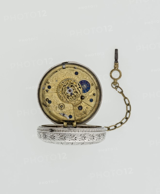 Pocket watch with key. Maker: Eardley Norton born 1728, died 1792, watchmaker; casemaker: APD Germany, 3rd quarter of the 18th century. Pocket repeater in two silver cases: smooth outer case and inner case with framed glazed lid. Mechanism cover engraved with an openwork floral acanthus twig, with winding hole and bell. White enameled dial with black Roman hour numerals, minute scale marked with dashes, calendar with Arabic numerals, three steel hands hour and minute in openwork weave; third straight hand indicating days of month. Small seconds subdial with Arabic numerals at bottom. Dial signed EARDLEY NORTON / LONDON. Movement: gilded brass with circular plates connected by pillars; spring-driven with spindle escapement. Lower plate with openwork crown richly decorated with acanthus tendrils and engraved acanthus volutes; cut-out reserve bears engraved signature Eardley / Norton London. Preserved winding key on a chain. Date: 3rd quarter of the 18th century. Places: case Germany; mak...