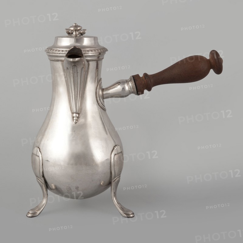 Coffee pot by F. Picard fl. ca. 1798–ca. 1809. Silver, c. 1798–1809. Paris, France. Vessel: height 46.0 cm; width 8.5 cm; depth 8.5 cm; weight 248.2 g., A reflective metal pitcher with a bulbous body and decorative raised ridges stands on a group of curved legs; it has a hinged lid with a small finial, a straight spout with a fluted decorative panel, and a horizontal cylindrical metal attachment connecting to a turned wooden handle. The visible colors are silver on the metal parts, brown on the wooden handle, and a neutral light gray background.