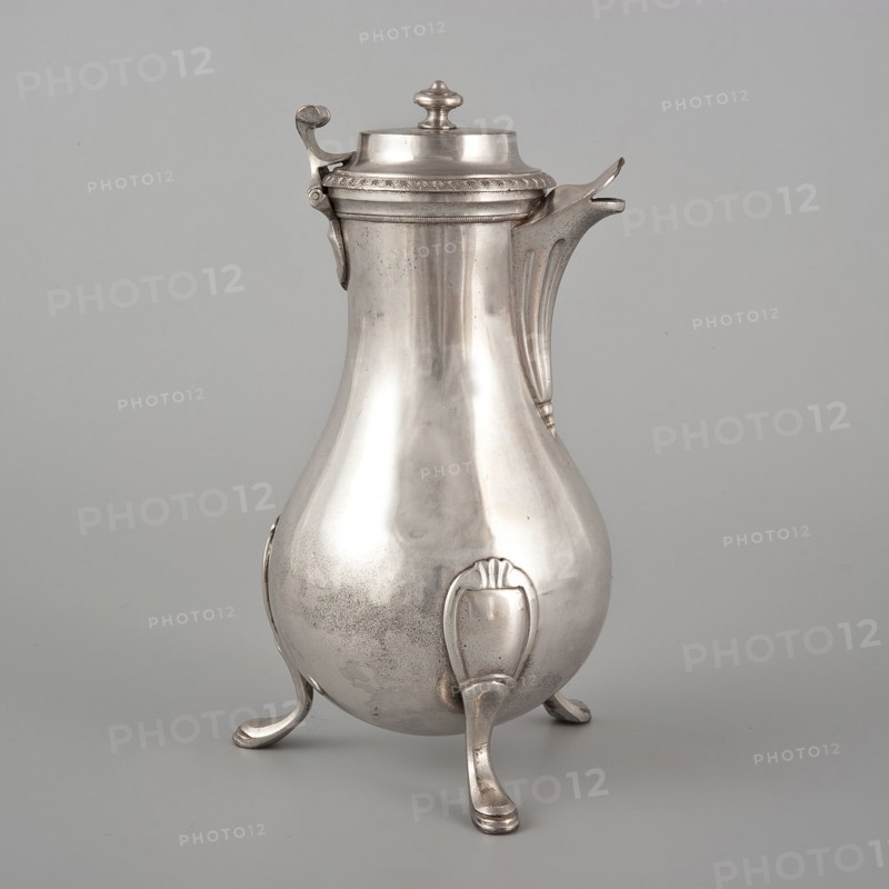 Coffee pot by F. Picard fl. ca. 1798–ca. 1809, silver, Paris, France, ca. 1798–1809. Vessel coffee pot, height 46.0 cm, width 8.5 cm, depth 8.5 cm, weight 248.2 g., A rounded metal pitcher with a hinged lid and a curved spout stands on three ornate legs, showing a smooth, reflective surface with some darker areas and faint speckling; the pitcher, lid, spout, handle accents, and legs all appear in silvery gray tones against a light gray background.