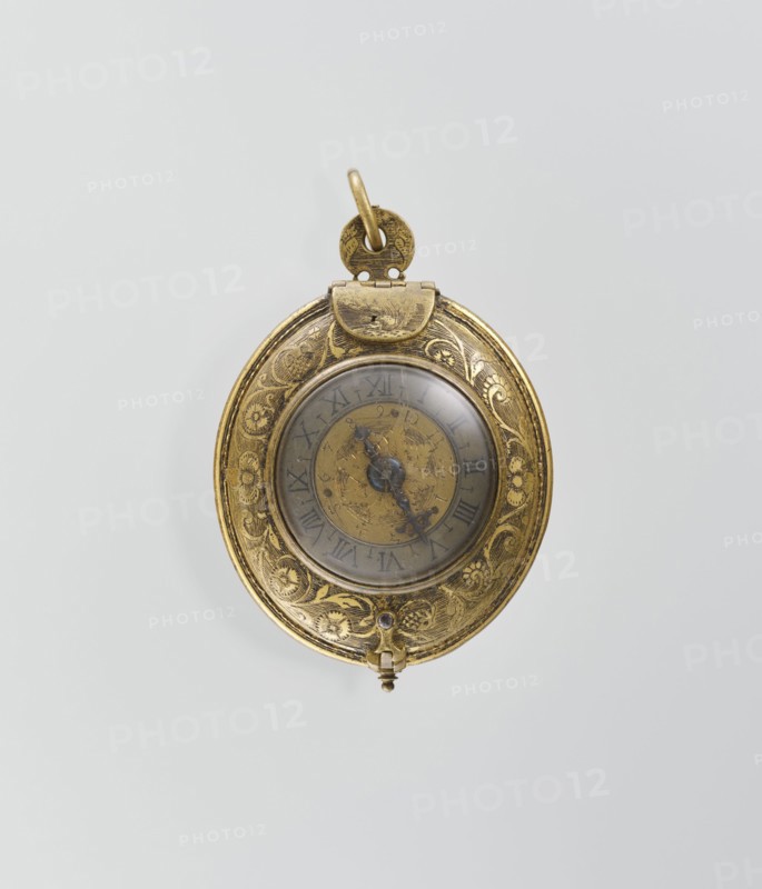 Pectoral watch, Stosch, Israel fl. 1st half of 17th century watchmaker, baroque, floral ornament, grotesques. Pectoral watch in an oval case, frame with a circular glazed cut-out, beneath which a dial with a silver ring with hour numerals. Frame decorated with an engraved tendril. Underside open-work, with a motif of a winged bust passing at the bottom into a tendril. Around it is a tendril motif. Openwork sides of the case, with a tendril motif. Mechanism with a striking device, with the signature I. STOSCH. 17th century, Wroclaw, timepiece, height 5.3 cm, width 3.5 cm., A single oval pocket watch with an ornate metal case in gold tones suspended against a pale gray background; the case shows engraved floral and scrollwork decoration around a circular glass face, and beneath the glass a round dial with decorative hands in darker metal; a small hinged clasp and a loop for attaching the watch are visible at the top, and a tiny knob projects from the bottom; visible colors include gold, ...