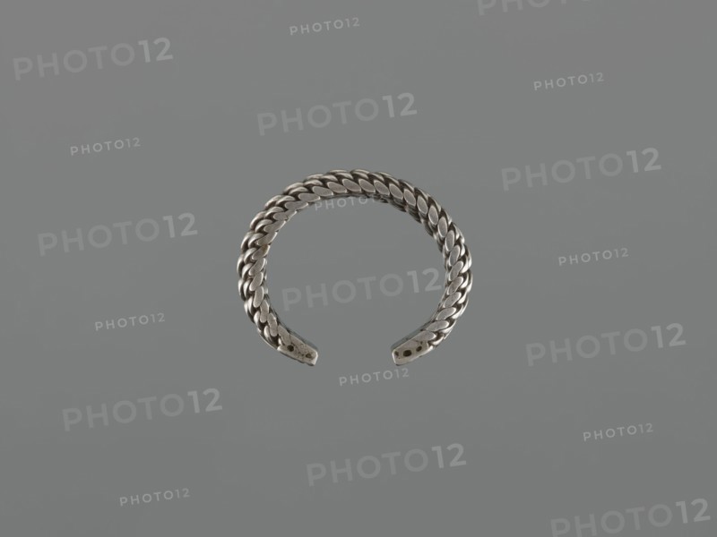 Bracelet, 19th century, Middle East, tugra motif; Islamic art; body/female/hand ornament; fashion accessory; materials: jewelry; height 2.5 cm, width 7.0 cm, weight 170 g., A braided metal cuff bracelet with an open end displayed against a uniform gray background; the bracelet appears silver in color with a woven texture and slightly darker shadows along the braided links and the ends of the cuff.