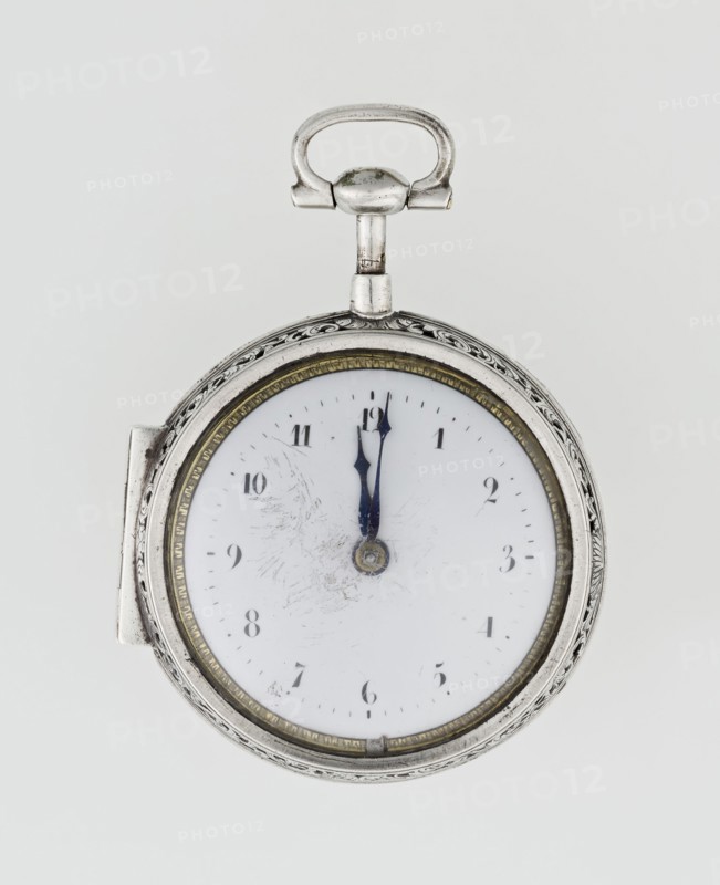 Pocket watch by Carl Willougby, 2nd quarter of the 18th century, London, England. Silver case, partially openwork, richly engraved over the entire surface with acanthus twig and flowers, acanthus scrolls, fish-scale ornament, shells, birds, and two masks male and female. Central circular reserve of acanthus twig, volutes and fish scales enclosing a bell. Glazed lid set in an openwork frame decorated with a floral twig and a broken ribbon. Mechanism between two circular plates supported by columns, with spindle escapement, a worm with chain, and a balance drum; pocket watch with striking function. Gilded openwork crown engraved with an acanthus twig, combined with an openwork foot and a woman's mask. White enameled dial edged with a gilded knurled ribbon, hour markers in Arabic numerals, minutes as vertical lines; steel hands. Height 8 cm, width 5.5 cm, dial diameter 4.5 cm., A round pocket watch with a silver metal case and ornate edge sits against a pale gray background, showing a whi...