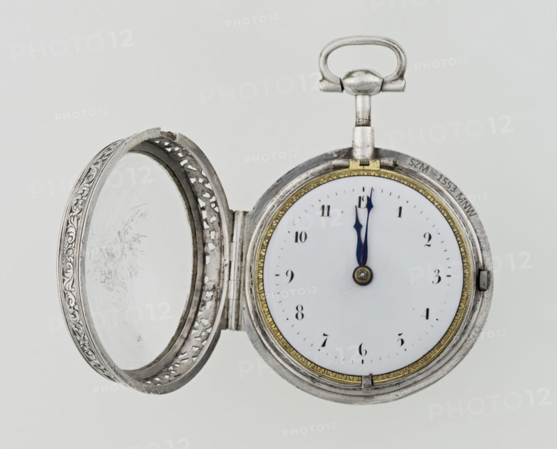 Pocket watch by Carl Willougby, 2nd quarter of the 18th century, London, England. Silver, partially openwork case with engraved ornament covering the entire surface: acanthus twigs and flowers, birds, two masks male and female, acanthus scrolls, fish-scale ornament, shells. Central circular reserve of acanthus twig, volutes and fish scales containing a bell. Glazed lid enclosed by an openwork frame decorated with a floral twig and a broken ribbon. Mechanism between two circular plates supported by columns, with a spindle escapement, a worm with a chain, and a balance drum; pocket watch with striking function. Gilded openwork crown engraved with an acanthus twig, combined with an openwork foot and a woman's mask. White enameled dial edged with a gilded knurled ribbon, hour markers in Arabic numerals, minutes marked with vertical lines; steel hands. Height 8 cm, width 5.5 cm, dial diameter 4.5 cm., A circular pocket watch with its ornate lid open, showing a white face and a pair of dark ...