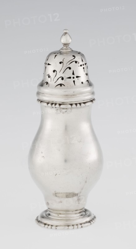 Powdered sugar bowl, powdered sugar bowl pear-shaped with domed openwork cover topped with a bowl; openwork, astargal ornament. Maker: Burbidge, Richard 1847–1917, goldsmith. Seller: Harrod's Stores Ltd London. Function: sugar vessel. Materials/form: dish, pear-shaped powdered sugar bowl on a circular profiled foot. Date: 1913/1914. Place: London, England, Great Britain. Dimensions: height 15 cm, diameter 5.9 cm, weight 152 g., A metallic, bulbous container with a rounded base and a narrower neck topped by a domed removable lid that has a small finial; the lid features decorative cutout patterns in flowing, curved shapes. The body and lid are shiny silver in color with areas of subtle tarnish and small surface scratches, and the base has a ridged decorative edge. The background is a smooth, light gray.