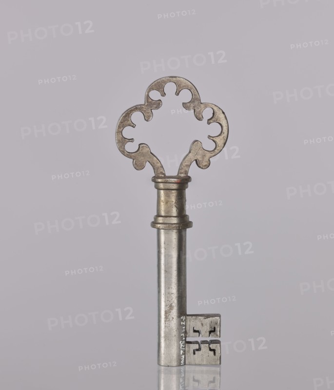 Lock key, Taszynski, Michal fl. 1820–1838 author. Door lock with pasquils and key No. 114. Made in 1861 by Michal Taszynski, marked with the guild marks of the Warsaw Locksmiths' Assembly. Distinguished by precise workmanship and the ingenious use of protruding side bolts pasquils that lock the door simultaneously in three directions: top, bottom, and middle. Ornamentation on the top has a light pattern. Mechanism: resting bolt with two heads and a latch bolt between them that opens with a half-turn; a full movement of the key activates the double bolt and locking mechanism. Neat workmanship. Inside the box, on the side, a hallmark is stamped twice – a striding figure with a large key likely a striding bear with a key, styled like the city's 19th-century coat of arms. Szewczykowski attributed the lock to Michal Daniel Taszynski born 1836, son of Michal Taszynski, a locksmith specializing in polished steel accessories; said to have made this piece in 1861. Height 11 cm, width 4.3 cm, de...